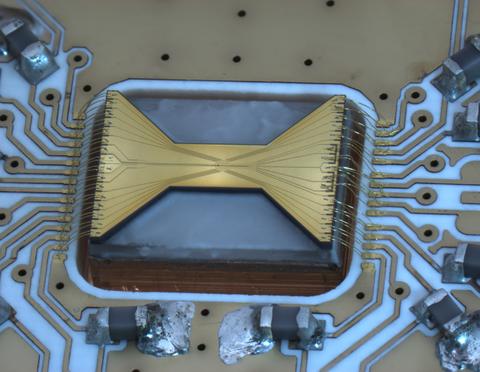 A rectangular chip features a brass-colored bow-tie shape on black background.