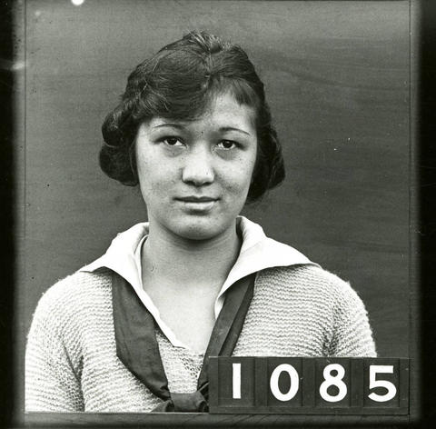 Head-and-shoulders photo of Asian woman wearing a blouse and neck scarf