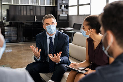 Business people talking in meeting with face mask 