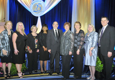 Photo of Barb Fischer with a group of people at the Quest Gala.
