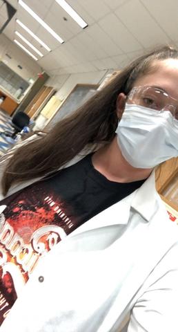 woman wearing a lab coat and safety glasses