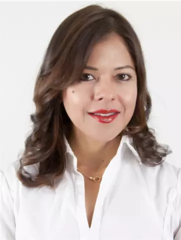 Headshot of Veruska Malavé, a woman with long brown hair, wearing a white collared shirt, smiling.