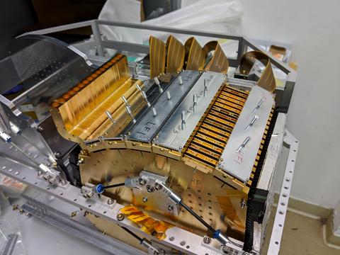 Scientific instrument has bronze-colored keylike parts and silver-colored cover panels.