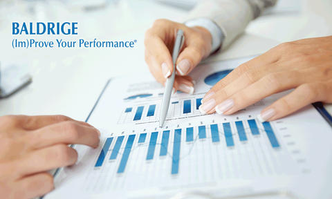 Baldrige (Im)Prove Your Performance showing people reviewing charts.