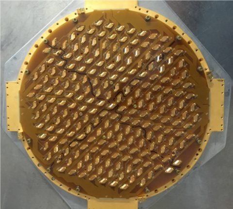 A gold-colored circle is studded with rows of sensors. 