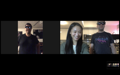 Screenshot of one male wearing a black tshirt on the left wearing a AR headsets and video chatting with two individuals on the right (one female wearing a green hoodie with long brown hair and one male wearing a tshirt and AR headset).