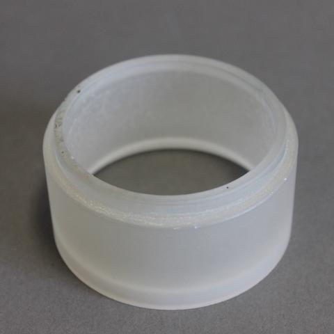 A short whitish cylinder of glass on a gray surface