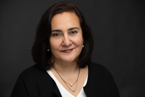 Head shot of a woman on a dark gray background