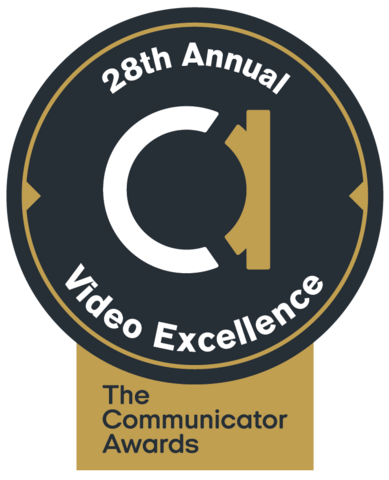 black circle. big white and gold lowercase a in the middle. Around the edges: 28th annual video excellence in white. Gold box at bottom that includes black words: The Communicator Awards