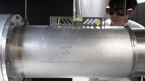A metal cylinder shown from the side has handwriting on it that says, "Ions sit here."