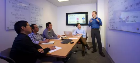 Dr. Carl Miller, a mathematician in the NIST Computer Security Division and a Fellow of the Joint Center for Quantum Information and Computer Science, discusses quantum algorithms with QuICS students and postdocs. 