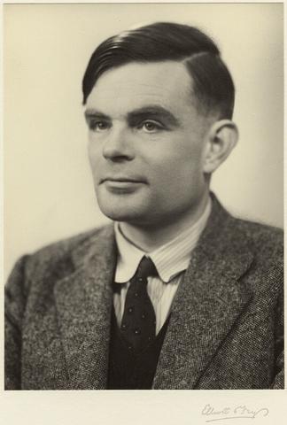 black and white headshot from chest up. Man is wearing a suit jacket and tie