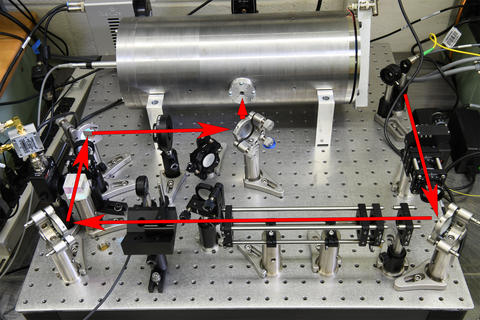 illustration showing the path of laser light before it enters the optical cavity inside the metal cylinder