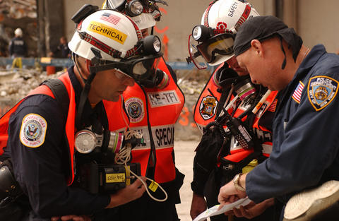 Two firefighters speak with two police officers during an emergency