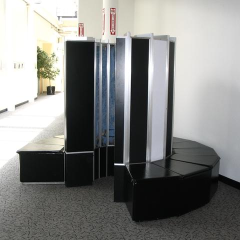 A tall computer console is shaped in a semi-circle, standing inside a hallway.