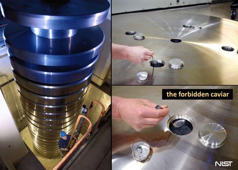 Text reads "the forbidden caviar" near a small access hole on a large cylinder, part of an enormous stack of weights. A person is spooning tiny metal balls out of the access hole.  