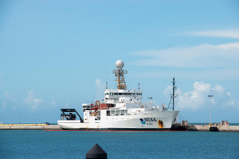 Photograph of a NOAA research vessel on blue water against a blue sky