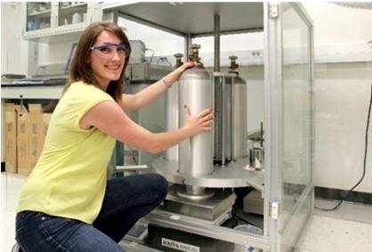 Photograph of a NIST scientist with a balance for weighing gas cylinders.