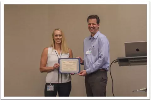 Beth Ordeman, Chair of OSAC's Human Forensic Biology Subcommittee accepting the Outstanding Group Award from JP Jones, OSAC Program Manager