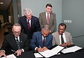five men signing a piece of paper