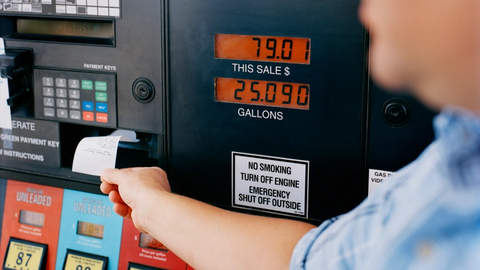 Man pulling receipt from gas pump