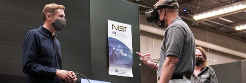 First responder using virtual reality head set inside the Public Safety Immersive Test Center with NIST and FirstNet Authority staff.