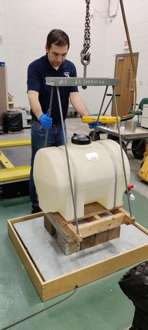 Weighing the tank containing the collected water after testing was complete.