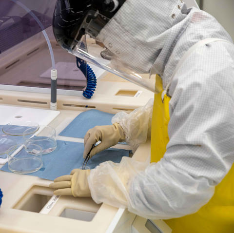 A woman wearing protective gear works in the NIST nanofabrication facility