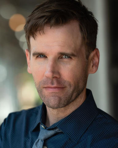 headshot of a man in a tie