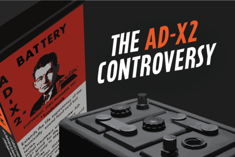 Red box of AD-X2 on the left. Words: The AD-X2 Controversy. Partial view of a car battery.
