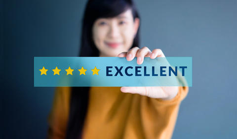 Customers photo showing woman holding a five star excellence sign.