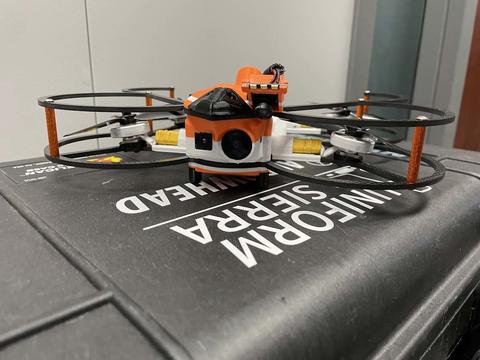 Orange drone on a table.