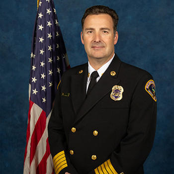 Headshot of a man in uniform standing in front of the American flag