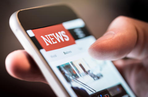 Online news in mobile phone. Close up of smartphone screen. Man reading articles in application. Hand holding smart device. Mockup website. Newspaper and portal on internet