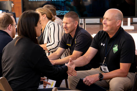  Two 5x5 attendees shake hands during the “speed networking” session.