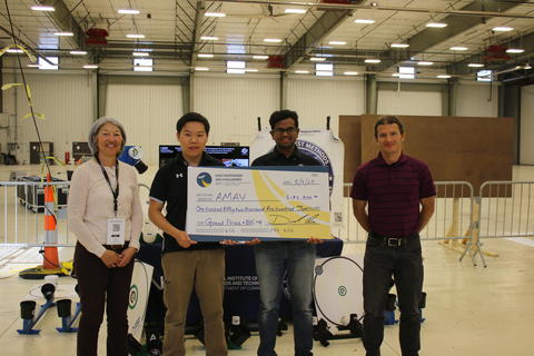 Two members of the University of Maryland AMAV receiving an award check from PSCR representatives.