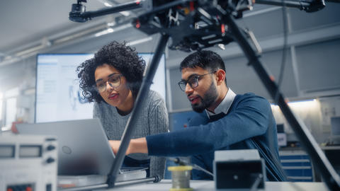 A man and woman work together on a laptop. 