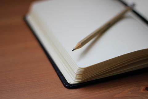 Image of a pencil lying on top of an open notebook