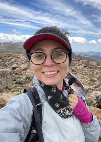 Headshot of Aly Artusio-Glimpse atop Mt. Flora.