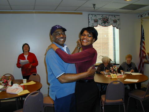 Jackie Deschamps dances with a resident of a senior adults center.