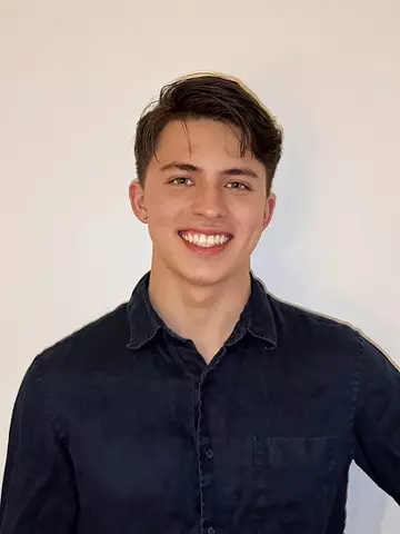George Sellers poses for a casual head shot against a white wall. 
