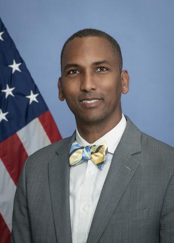 Indoor headshot of Richard-Duane Chambers in front on an American flag