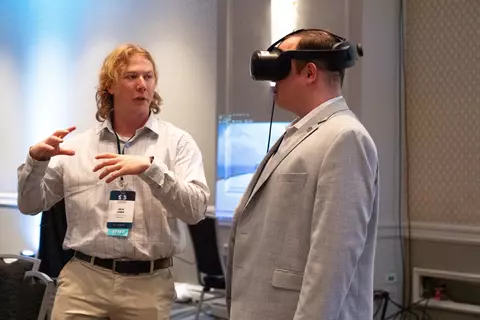 PSCR staff member demoing an AR headset with a 5x5 attendee