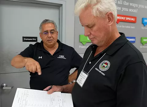 David Sefcik reviews an inspection report with a Massachusetts Weights and Measures Official James Shattuck