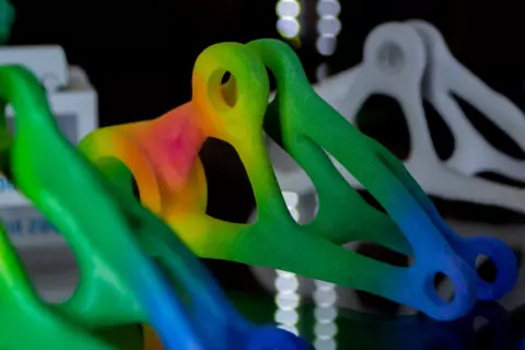 an abstract rainbow colored shape 3D printed by fusing powdered material together