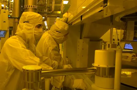 Photo of workforce in clean suits in the manufacturing fab center in New York