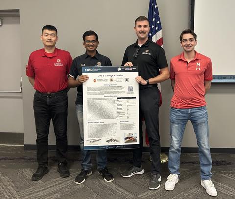 Image from UAS 5.0 Stage 3 live event of Team AMAV members holding their Stage 3 solution poster.