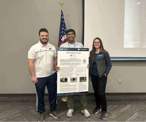 Image of ARCC team members at UAS 5.0 Stage 3 live event; they are holding their Stage 3 solution overview poster.