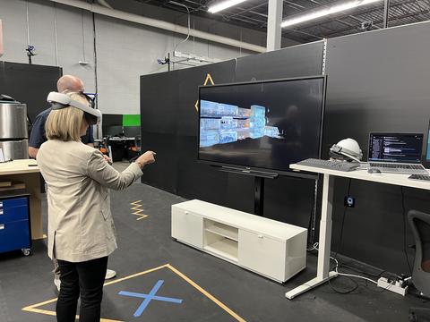 A woman wears a VR headset and tries out a tool