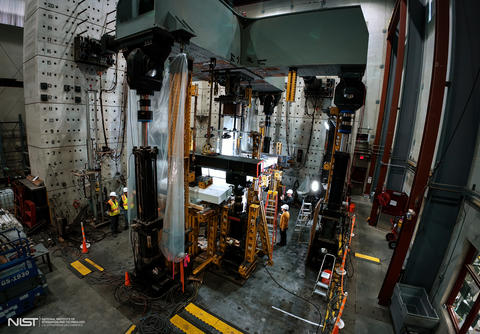 High-ceilinged lab space holds large pieces of equipment surrounding concrete slabs.  